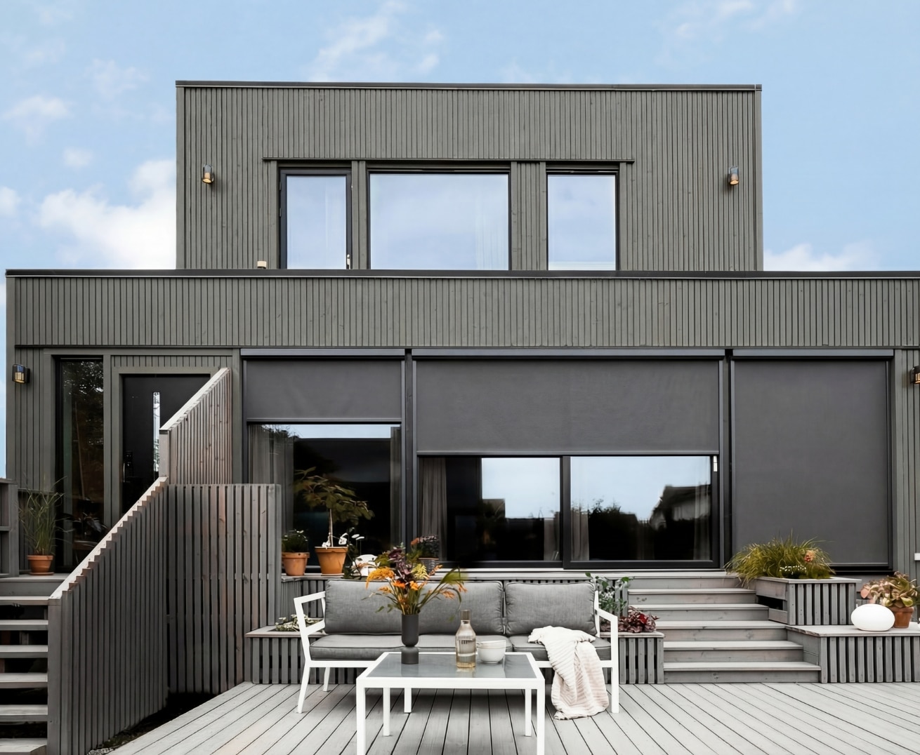 Tre store zipscreens på et grått moderne hus.